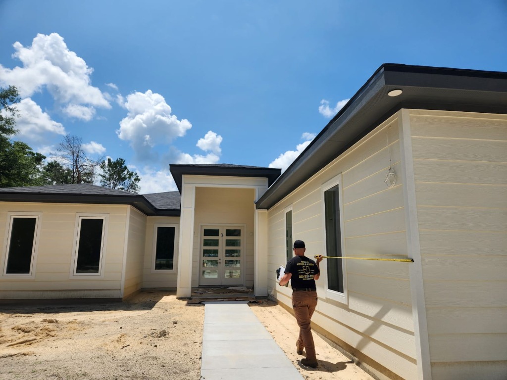 Technician measuring house for gutter installation